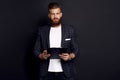 Portrait of confident concentrated self-assured handsome bearded guy writing information to the documents on clipboard in hid