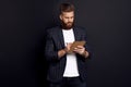 Portrait of confident concentrated self-assured handsome bearded guy writing information to the documents on notebook in hid hands