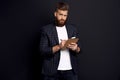 Portrait of confident concentrated self-assured handsome bearded guy writing information to the documents on notebook in hid hands