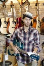 Portrait of a confident customer with guitar in music store