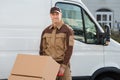 Confident Delivery Man Pushing Parcels On Handtruck