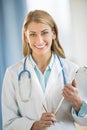 Portrait Of Confident Doctor Holding Clipboard In Clinic Royalty Free Stock Photo