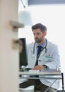 Portrait of confident doctor using computer at desk in hospital Royalty Free Stock Photo