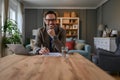 Portrait of confident elegant businessman with laptop and documents on desk sitting in home office. Royalty Free Stock Photo