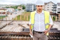 Confident engineer working with laptop on construction site