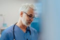 Portrait of confident ER doctor standing in hospital emergency room. Handsome doctor in scrubs standing in modern Royalty Free Stock Photo