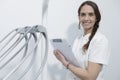 Portrait of a young woman dentist, recording in document, on background dental clinic Royalty Free Stock Photo