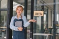 Portrait of confident female barista standing at counter. Woman cafe owner in apron looking at camera and smiling while Royalty Free Stock Photo