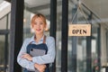 Portrait of confident female barista standing at counter. Woman cafe owner in apron looking at camera and smiling while Royalty Free Stock Photo