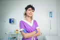 Portrait of confident female doctor. Female ENT doctor in purple medical clothes posing in office of the clinic on her Royalty Free Stock Photo
