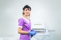 Portrait of confident female doctor. Female ENT doctor in purple medical clothes posing in office of the clinic on her Royalty Free Stock Photo