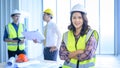 Portrait of confident female engineer standing on frontage while colleagues discussing and meeting on background Royalty Free Stock Photo