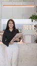 Portrait of confident female entrepreneur standing behind counter of coffee shop and smiling to camera. Royalty Free Stock Photo