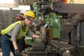 Portrait of confident female worker wearing hard hat and safety glasses working in industrial