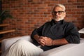 Portrait of a confident gray-haired man. Handsome pensioner relaxes in a chair. Luxurious retirement life Royalty Free Stock Photo