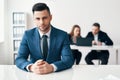 Portrait of confident handsome businessman sitting in office with his business team on background Royalty Free Stock Photo