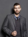 Portrait of confident handsome businessman in suit on gray wall background. Fashionable beautiful man looks at frame Royalty Free Stock Photo