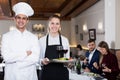 Portrait of confident male chef and smiling waitress Royalty Free Stock Photo