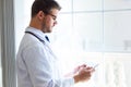 Confident male doctor using his digital tablet in the office. Royalty Free Stock Photo