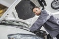 Portrait of confident male repair worker repairing car engine in repair shop