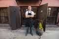 Portrait of confident male salesperson standing arms crossed outside coffee store