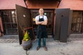 Portrait of confident male salesperson standing arms crossed outside coffee store