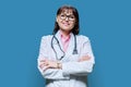 Portrait of confident mature female doctor on blue background Royalty Free Stock Photo