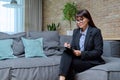 Portrait of female psychologist with clipboard sitting on couch in office Royalty Free Stock Photo