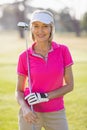 Portrait of confident mature golfer woman carrying golf club Royalty Free Stock Photo