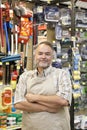 Portrait of a confident mature store clerk with arms crossed in hardware shop