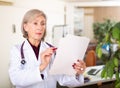 Portrait of woman doctor reading documents Royalty Free Stock Photo