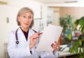 Portrait of woman doctor reading documents Royalty Free Stock Photo