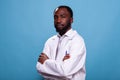 Portrait of confident medic in laboratory uniform posing with arms crossed on blue background Royalty Free Stock Photo