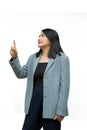 Portrait confident middle-aged Asian woman wearing gray jacket points her finger up on a white background Royalty Free Stock Photo