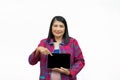 Portrait confident middle-aged Asian woman wearing pink casual wear pointing a finger to a tablet isolated on white background Royalty Free Stock Photo