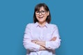 Portrait of confident middle-aged business woman on blue background Royalty Free Stock Photo