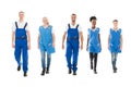 Portrait Of Confident Multiethnic Janitors Walking In Row Royalty Free Stock Photo