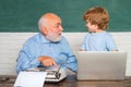 Portrait of confident old male teacher. Teacher helping his teen pupil on education class. Young boy doing his school Royalty Free Stock Photo