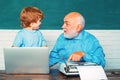 Portrait of confident old male teacher. Teacher helping his teen pupil on education class. Young boy doing his school Royalty Free Stock Photo