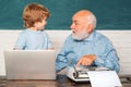 Portrait of confident old male teacher. Teacher helping his teen pupil on education class. Young boy doing his school Royalty Free Stock Photo