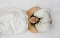 Portrait of a confident positive cheerful plump woman in bed hugging pillow. Cute plus size girl relaxing in bedroom, copy space