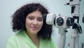 Portrait of confident positive woman sitting at retina camera in ophthalmologic clinic smiling posing. Plus-size