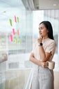 A confident Asian businesswoman stands by the window in her office Royalty Free Stock Photo