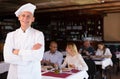 Portrait of confident professional pizzeria chef in restaurant hall