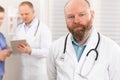 Portrait of a confident real doctor standing in front of his health team Royalty Free Stock Photo