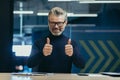 Portrait of a confident senior man businessman, executive director, boss sitting in the office at the table, smiling Royalty Free Stock Photo