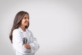 Portrait of confident senior woman doctor in workwear with stethoscope in hand standing with folded arms, free space Royalty Free Stock Photo