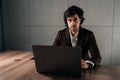 Portrait of confident serious businessman in suit sitting at workplace with laptop looking at camera. Successful CEO Royalty Free Stock Photo
