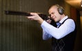 Confident shooter sighting in or zeroing shotgun in shooting gallery Royalty Free Stock Photo