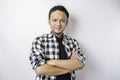 Portrait of a confident smiling Asian man wearing tartan shirt standing with arms folded and looking at the camera isolated over Royalty Free Stock Photo